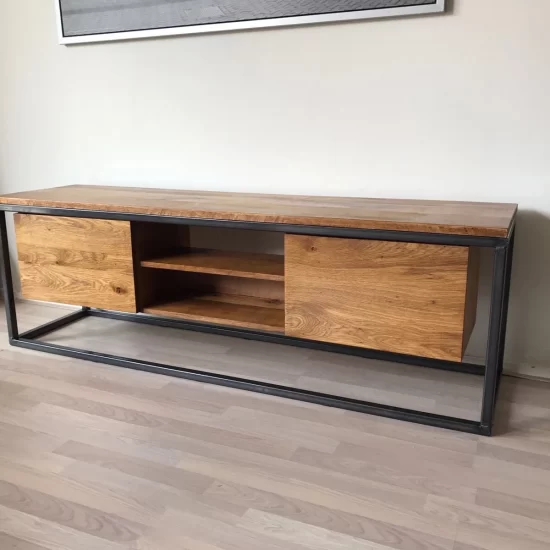 Een lang rechthoekige tv meubel van donkerbruin hout met een zwart stalen frame. In het midden onder het houten blad zijn twee planken gemaakt met aan beide zijden een dichte houten plank