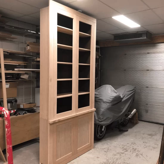 Een onbehandelde houten vitrinekast waaraan gewerkt wordt in de werkplaats van totaalhout.